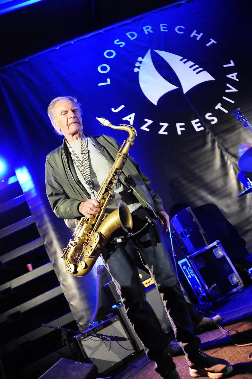 Saxofonist in blauw podiumlicht tijdens een jazzoptreden